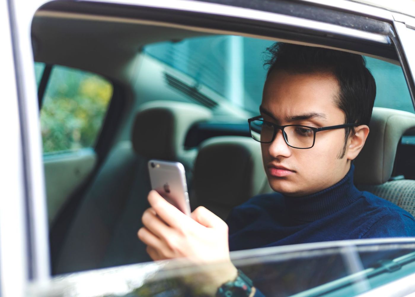 A driver checking a phone in the car